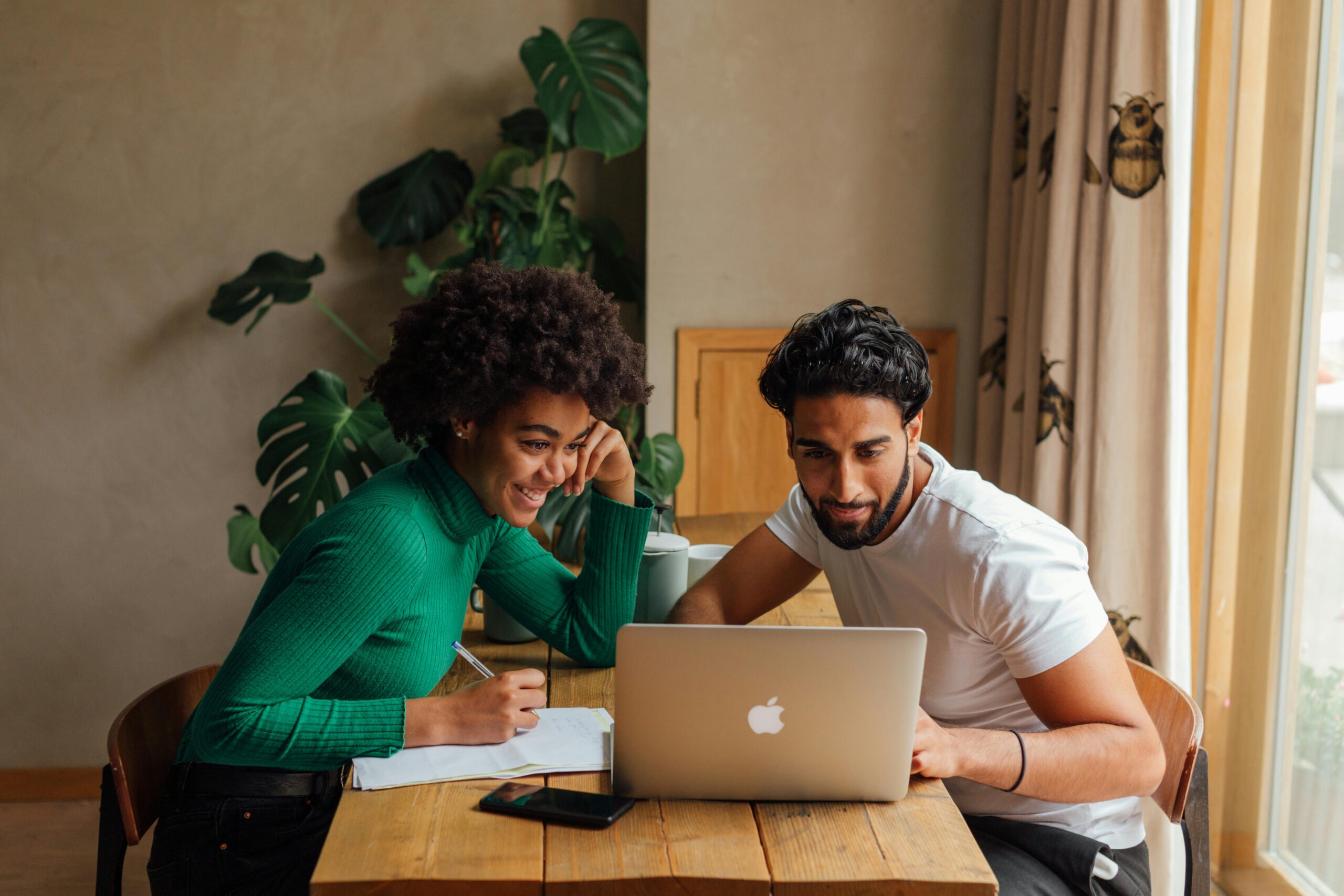 Online MBA and MS in Management students comparing career options and salaries while studying together on a laptop