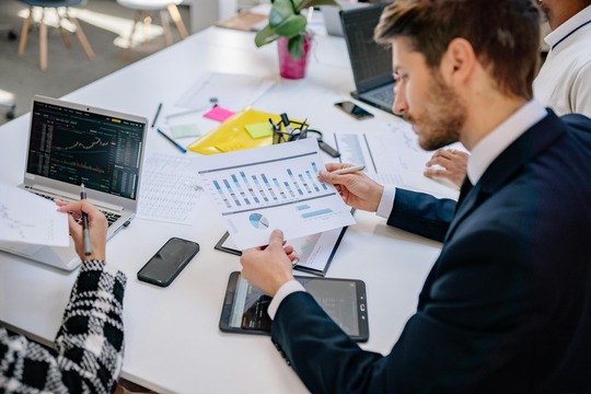 Young professionals making calculations in a modern business setting.